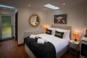 a bedroom with a large bed with towels on it at Heather Nook- luxury studio in Pitlochry in Pitlochry