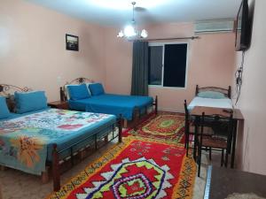 a room with three beds and a table and a table sidx sidx sidx at Maison Touria in Ouzoud