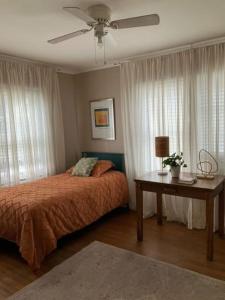 Schlafzimmer mit einem Bett und einem Tisch mit einem Ventilator in der Unterkunft Cozy Solo Escape in Lafayette