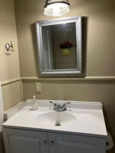 a bathroom with a sink and a mirror at Cozy Solo Escape in Lafayette