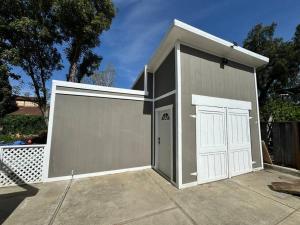a garage with a white door and a fence at Modern Minimalist Home in San Jose