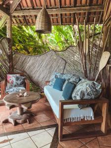 a porch with a couch and a table on a patio at Pousada Sage Point in Itacaré