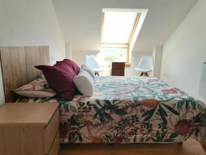um quarto com uma cama com colcha floral em PRECIOSO ATICO MONDARIZ em Mondariz