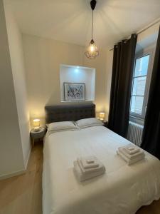 ein Schlafzimmer mit einem weißen Bett mit zwei Handtüchern darauf in der Unterkunft Le vie del vento - Garibaldi in Triest