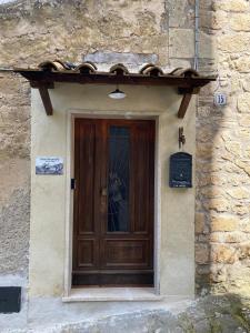 a wooden door on a stone building with a window at Casa Biscarello - Borgo e Lago in Grotte di Castro