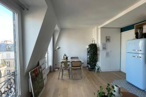Habitación blanca con mesa y nevera. en Nice 30 m near the district of Aligre, en París