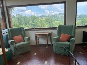 due sedie e un tavolo in una stanza con una grande finestra di Self catering Villa with pool in Umbria, Italy a Todi