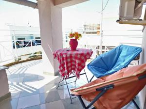 a table and two chairs with a vase on it at SUNTAN Lovely Apartment in Golem