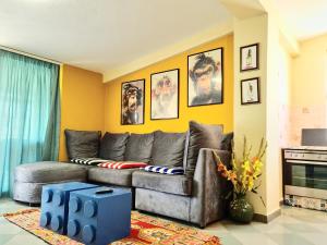 a living room with a gray couch and yellow walls at SUNTAN Lovely Apartment in Golem