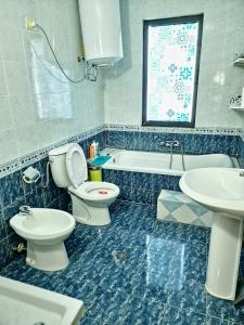 a bathroom with a toilet and a sink and a tub at SUNTAN Lovely Apartment in Golem +11 photos