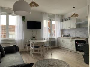 a living room with a table and a kitchen at 36 Maison entière,place parking devant garage in Dunkerque