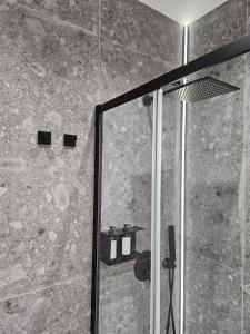 a shower with a glass door in a bathroom at Ossidiana Rossa Elegant Suite Vulcano in Vulcano