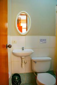 a bathroom with a sink and a toilet and a mirror at Hospedaje Guadalupe Inn in Máncora