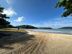 uma praia arenosa com um sinal de stop e o oceano em Maravilhosa Cobertura Apto com Vista para o Mar - Praia da Enseada em Ubatuba em Ubatuba