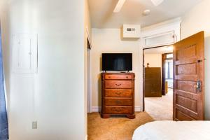 een slaapkamer met een televisie en een dressoir bij Centrally Located Beaver Falls Home with Fire Pit! in Beaver Falls