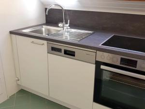 a kitchen with a sink and a stove at Seeappartements Excelsior in Velden am Wörthersee