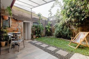 een patio met een tafel en stoelen in een tuin bij Casa Mundo in San José