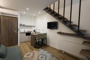 a living room with a staircase and a kitchen at Zen Private Suites in Ioannina