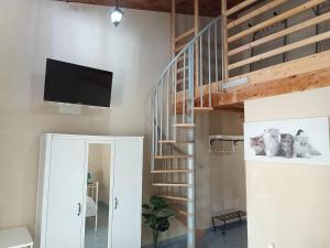 a living room with a spiral staircase with a flat screen tv at Agriturismo PALMERI in Avola