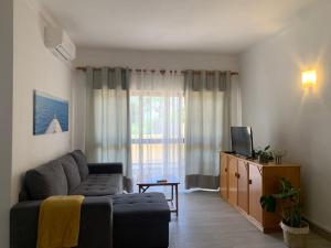 a living room with a couch and a television at Happydreams apartment in Albufeira in Albufeira