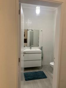 uma casa de banho branca com um lavatório e um espelho em Happydreams apartment in Albufeira em Albufeira