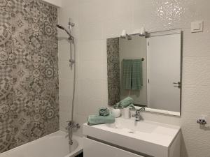 a bathroom with a sink and a tub and a mirror at Happydreams apartment in Albufeira in Albufeira