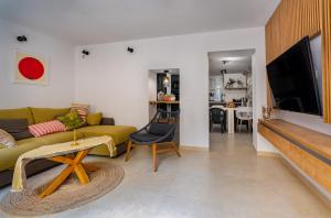 uma sala de estar com um sofá amarelo e uma televisão de ecrã plano em Kor Sea Home em Korčula