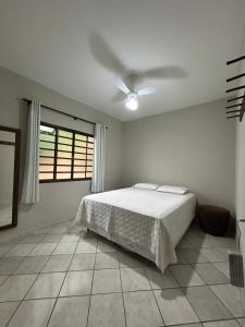 a bedroom with a bed and a ceiling fan at Mirante do Lago in Capitólio