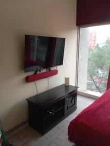 una camera da letto con una TV a schermo piatto sul muro di Greggs Place at Capital Hill Arcadia a Pretoria