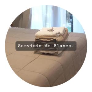 a mirror with a pile of towels on a bed at La Pausa, Departamentos y Casas in Chacras de Coria