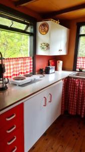 a kitchen with white cabinets and a sink and a window at Lovely retro cabin close to Geysir and Gullfoss in Selfoss