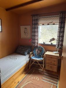 a small bedroom with a bed and a window at Lovely retro cabin close to Geysir and Gullfoss in Selfoss