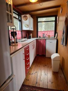 a kitchen with white cabinets and a wooden floor at Lovely retro cabin close to Geysir and Gullfoss in Selfoss