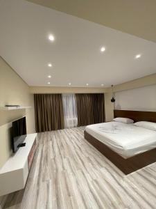 una grande camera da letto con un grande letto e una televisione di HOME 12 a Librazhd