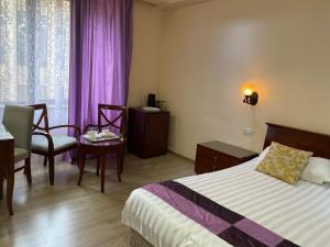 Habitación de hotel con cama, mesa y silla en DaMus apartments en Ereván