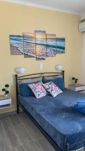 a bedroom with a bed with three paintings on the wall at Giovanni Apartments Kos Studio 20 in Kos +19 photos