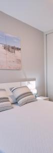 a bedroom with a white bed with a view of a beach at Apartamento de Julia in Santiago de Compostela