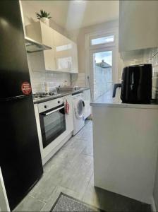 a kitchen with a stove and a dishwasher at Serenity Haven in Hackbridge