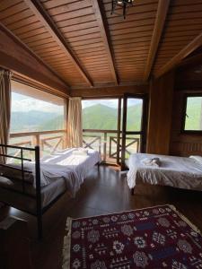 a room with two beds and a large window at Hotel Ananuri in Ananuri