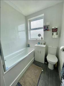 La salle de bains est pourvue d'une baignoire, de toilettes et d'un lavabo. dans l'établissement Serenity Haven, à Hackbridge