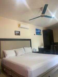 een slaapkamer met een bed en een plafondventilator bij Apartamentos Luna Turquesa Bacalar - Gratis Renta Bicicletas in Bacalar