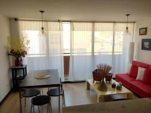 sala de estar con sofá rojo y mesa en Cómodo apartamento en Tocancipa, en Tocancipá