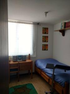 1 dormitorio con cama, escritorio y ventana en Cómodo apartamento en Tocancipa, en Tocancipá