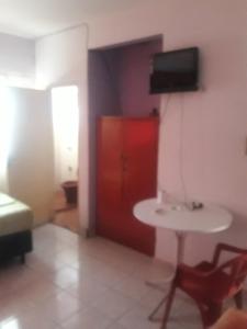 una habitación con una mesa pequeña y una puerta roja en San Miguel Hostal, en Villarrica