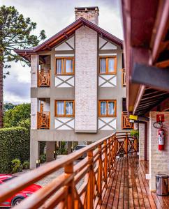 a house with a wooden walkway in front of it at Hotel Harmonia Monte Verde in Monte Verde