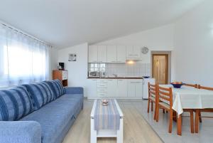 uma sala de estar com um sofá azul e uma mesa em Ferienwohnung für 4 Personen ca 45 qm in Stinjan, Istrien Istrische Riviera - b43252 em Štinjan