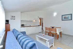 uma sala de estar com um sofá azul e uma cozinha em Ferienwohnung für 4 Personen ca 45 qm in Stinjan, Istrien Istrische Riviera - b43252 em Štinjan