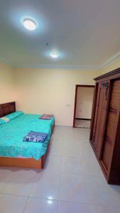 a bedroom with two beds and a cabinet in it at pharma beach resort x rent قرية الصيادلة بلطيم in Al Ḩammād