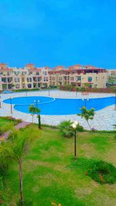 une grande piscine au milieu d'un complexe dans l'établissement pharma beach resort x rent قرية الصيادلة بلطيم, à Al Ḩammād
