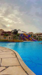 un parque acuático con un tobogán y un parque infantil en pharma beach resort x rent قرية الصيادلة بلطيم en Al Ḩammād